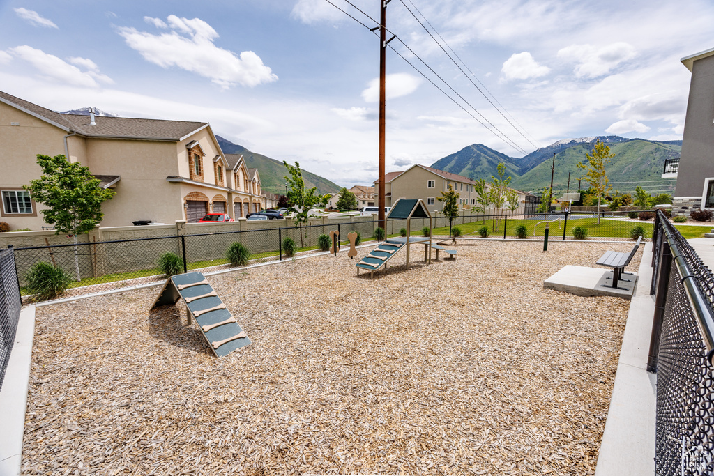 View of playground featuring a dog friendly area, a mountain view, fence, and a residential view