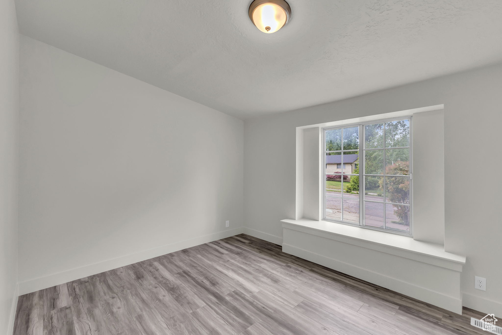 Empty room featuring wood finished floors and baseboards
