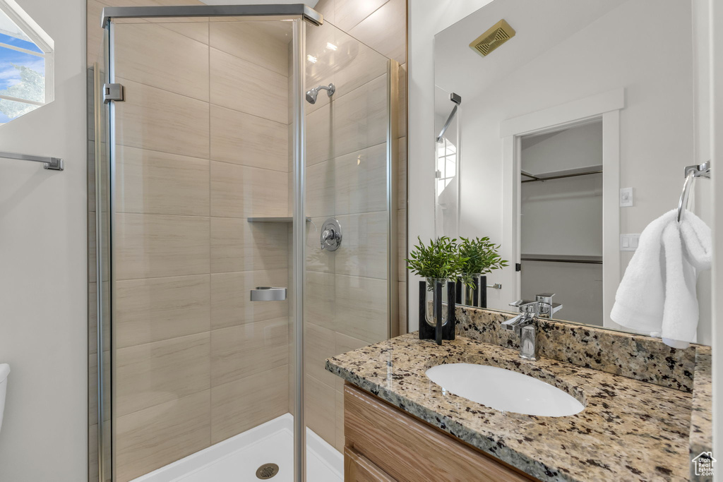 Full bath with a shower stall and vanity