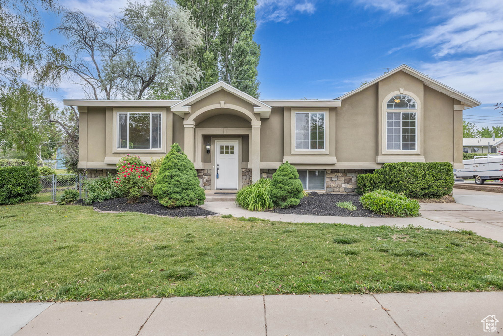 Raised ranch featuring stone siding and stucco siding