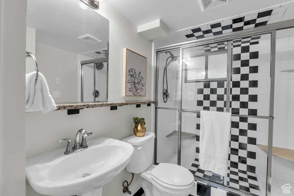 Full bath with a sink, a shower stall, and toilet