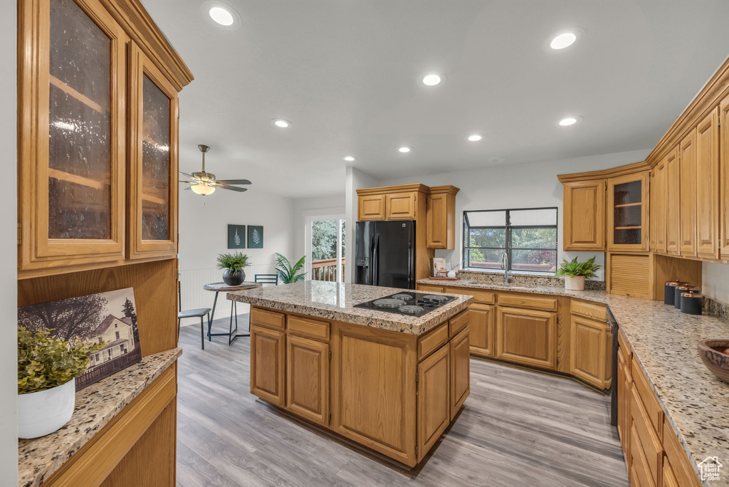 Kitchen featuring black appliances, a center island, light wood-style flooring, recessed lighting, and ceiling fan