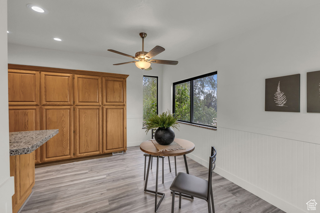 Dining room featuring wainscoting, light wood-style flooring, recessed lighting, and a ceiling fan
