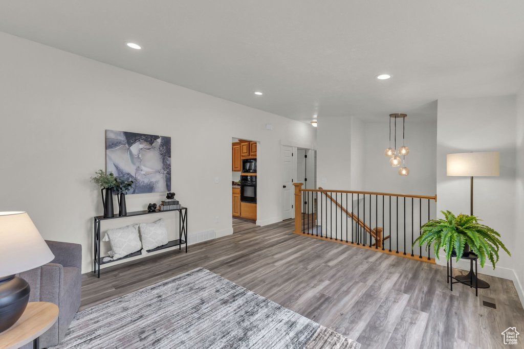 Sitting room featuring light wood-style floors, an upstairs landing, recessed lighting, baseboards, and a chandelier