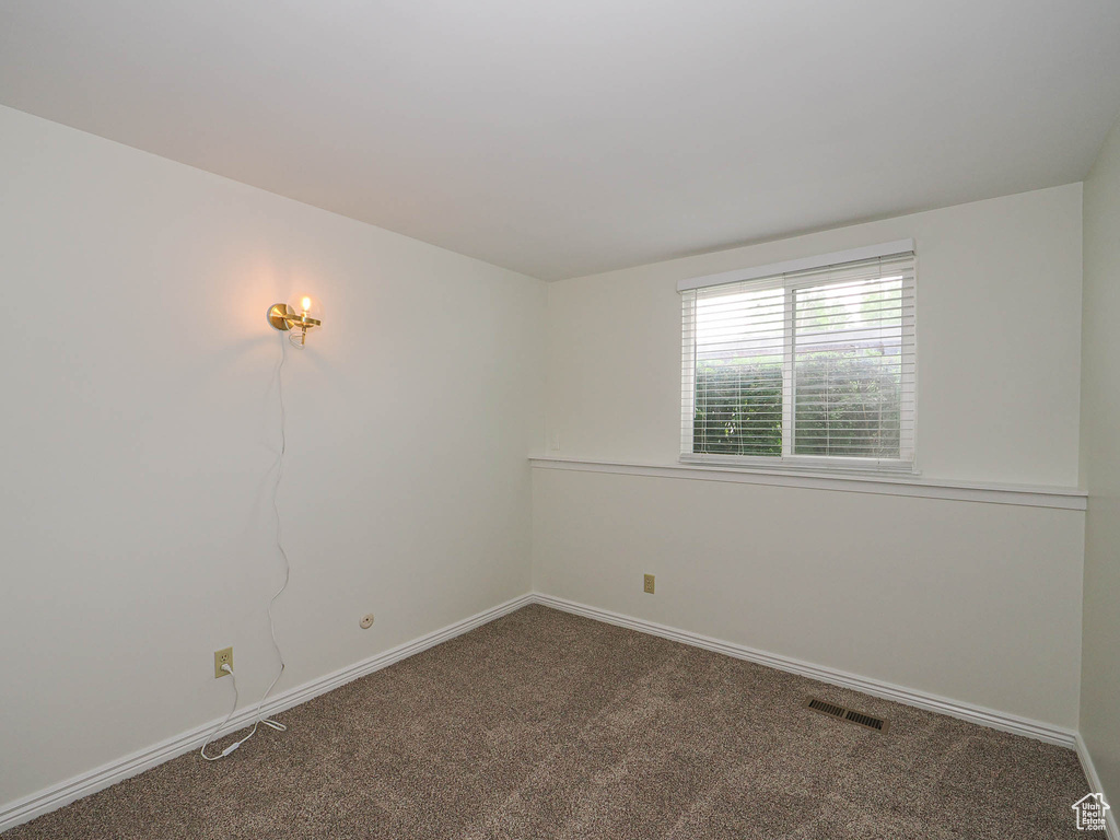 Carpeted empty room featuring baseboards