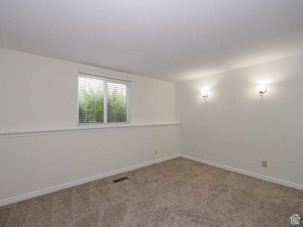 Carpeted empty room with baseboards