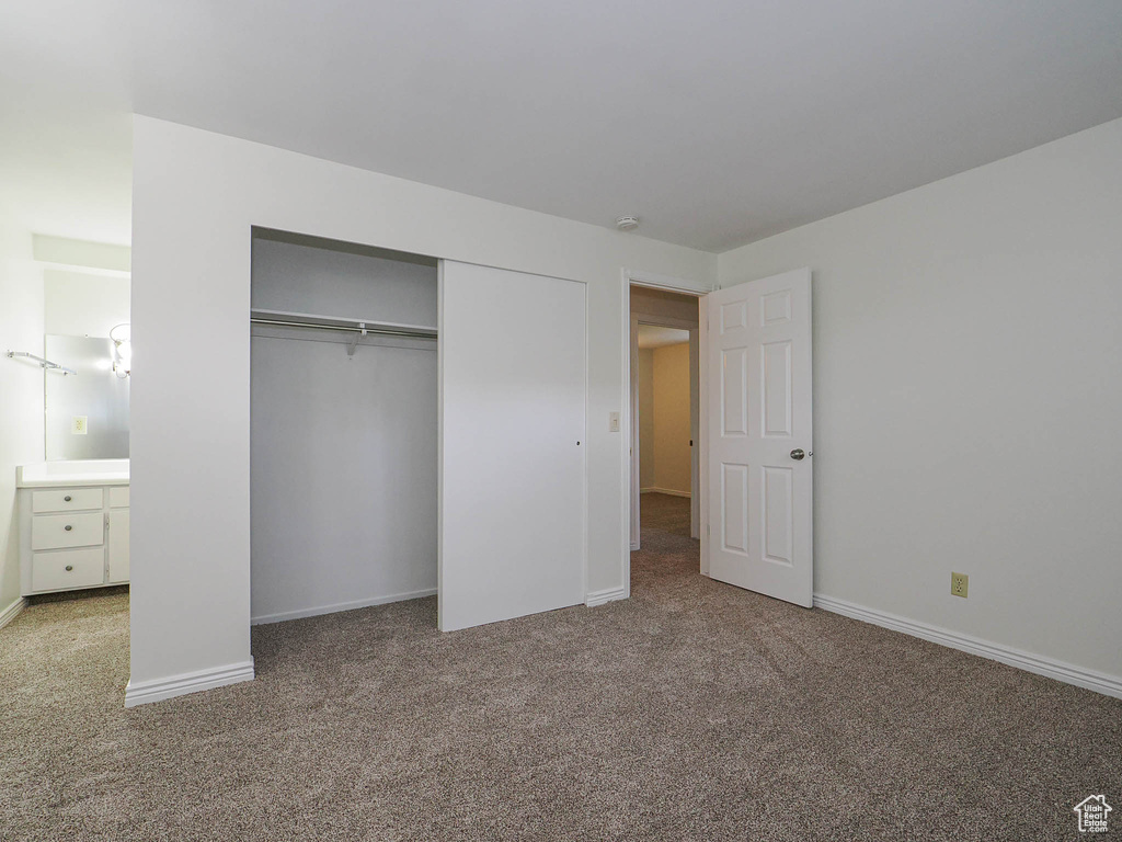 Unfurnished bedroom featuring carpet floors, a closet, and baseboards