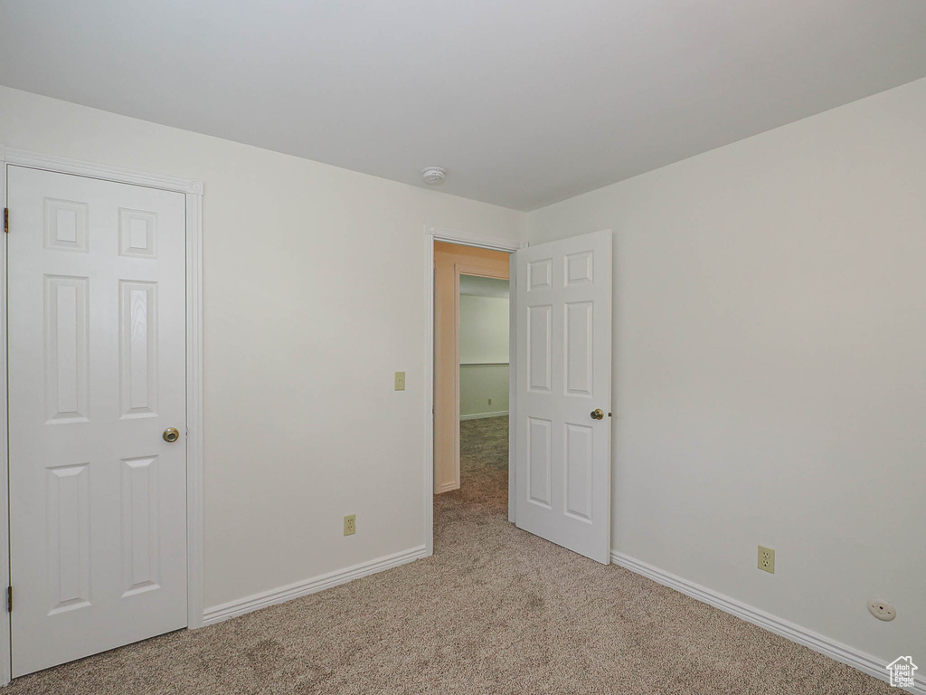 Carpeted spare room with baseboards and a smoke detector