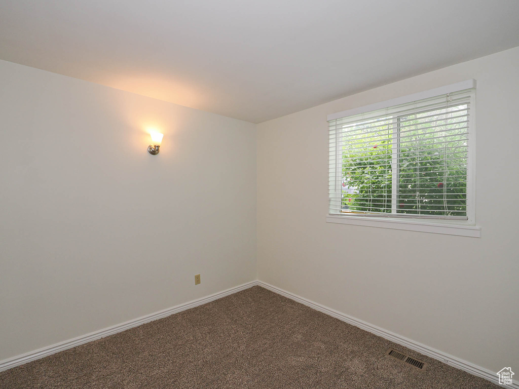 Carpeted spare room with baseboards