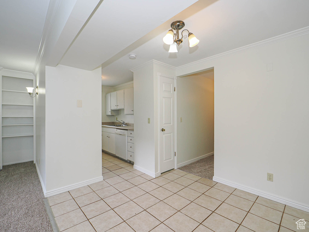 Unfurnished room featuring a sink, baseboards, light carpet, a chandelier, and ornamental molding