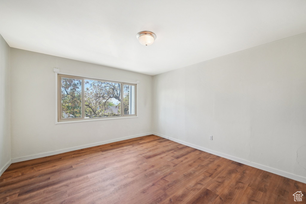 Spare room featuring wood finished floors and baseboards