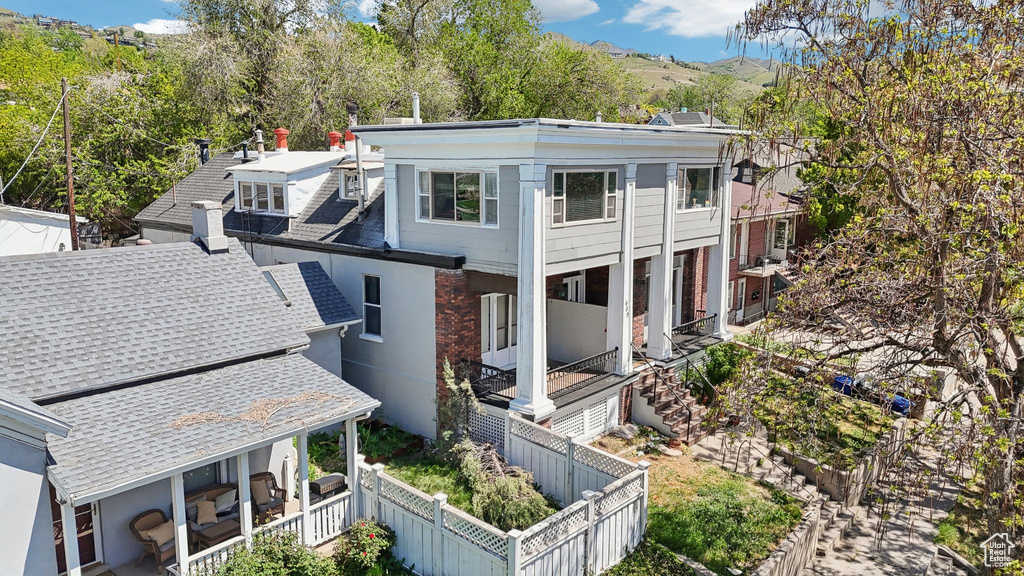 Back of house with roof with shingles, a fenced backyard, stucco siding, and a mountain view