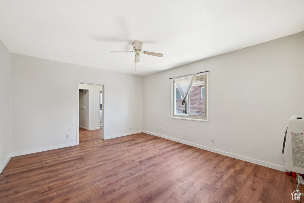 Spare room featuring wood finished floors, baseboards, and ceiling fan