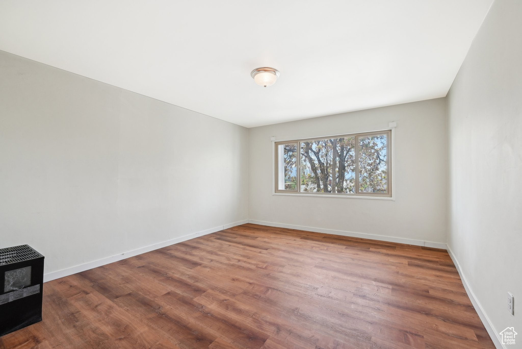 Unfurnished room featuring wood finished floors and baseboards