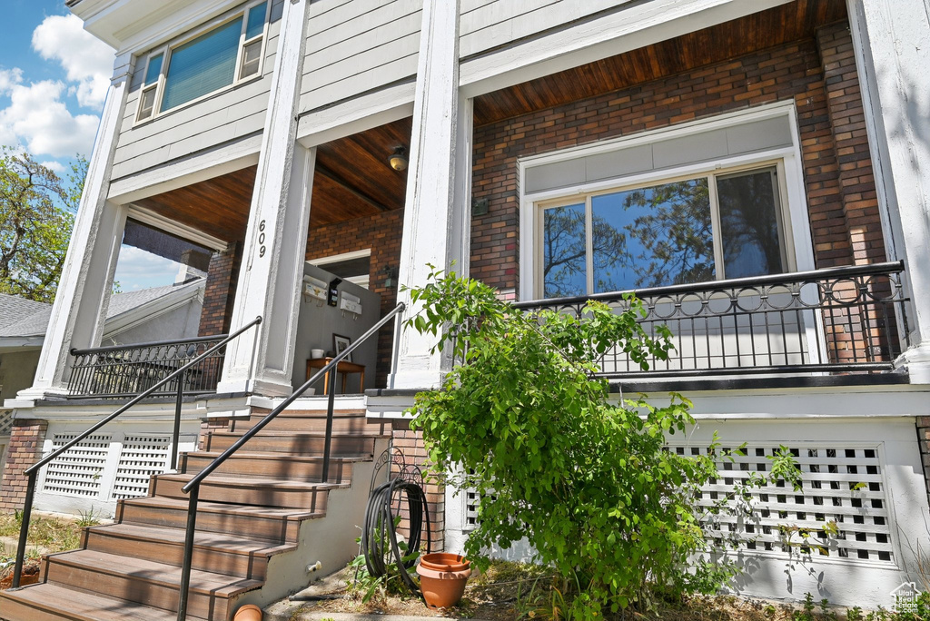 Property entrance featuring brick siding and a porch