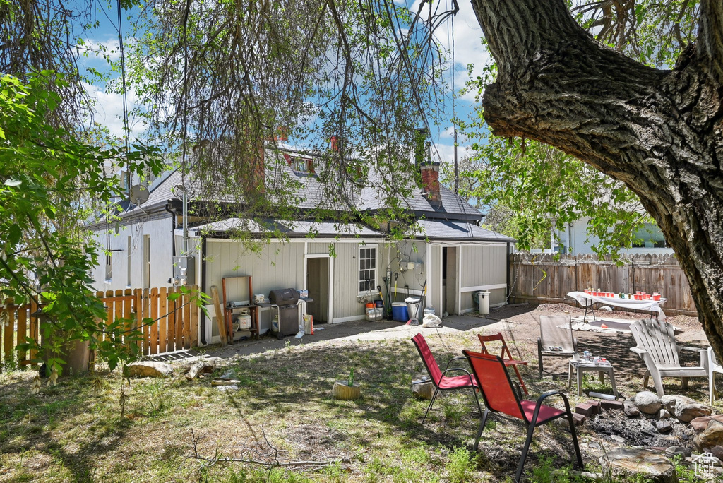 Rear view of house featuring a fenced backyard, a chimney, and a patio
