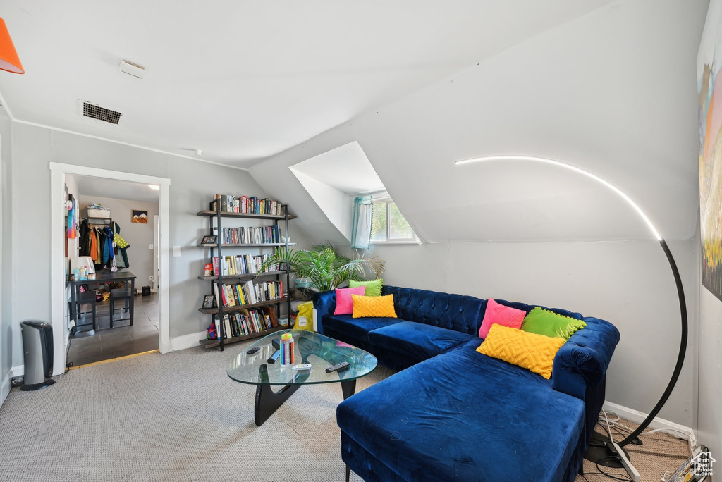 Carpeted living room with lofted ceiling and baseboards