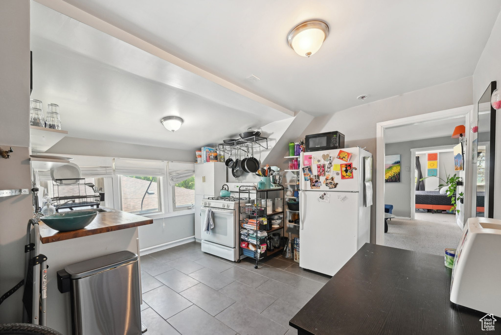 Kitchen featuring white appliances and tile patterned flooring