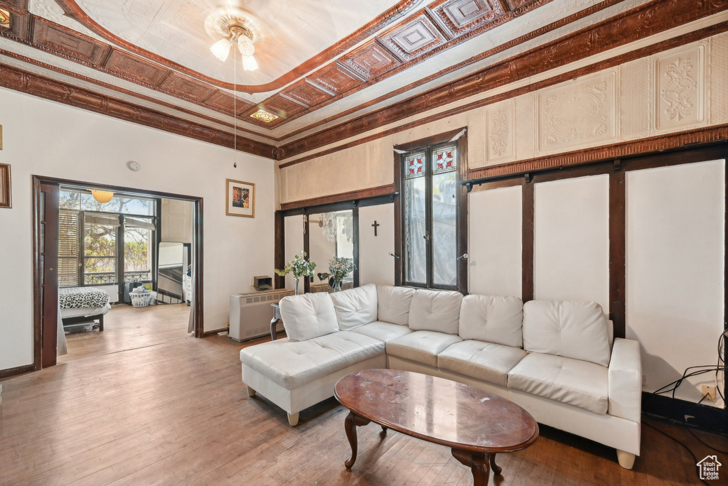 Living room featuring baseboards, light wood-style flooring, and a towering ceiling