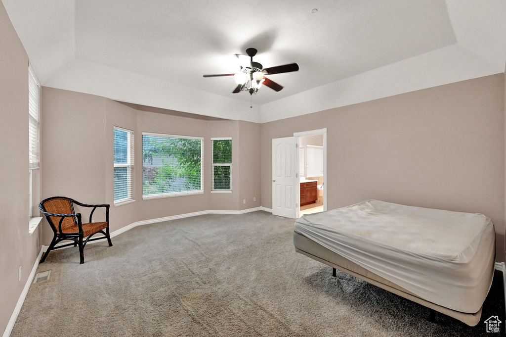 Carpeted bedroom with baseboards, ensuite bath, and ceiling fan