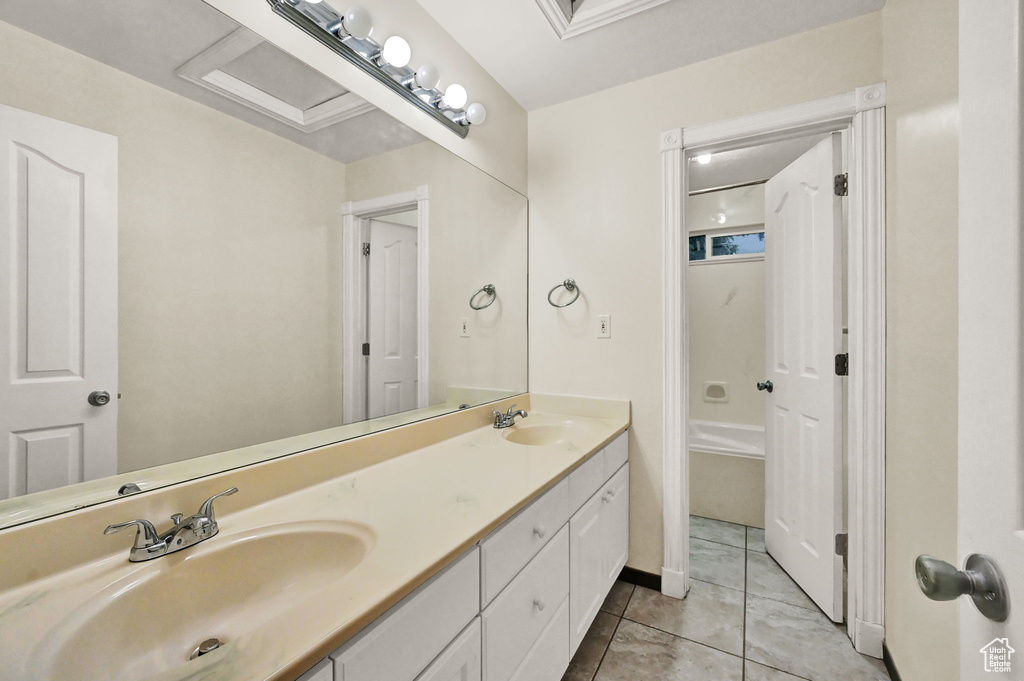 Bathroom with double vanity, tile patterned flooring, and baseboards