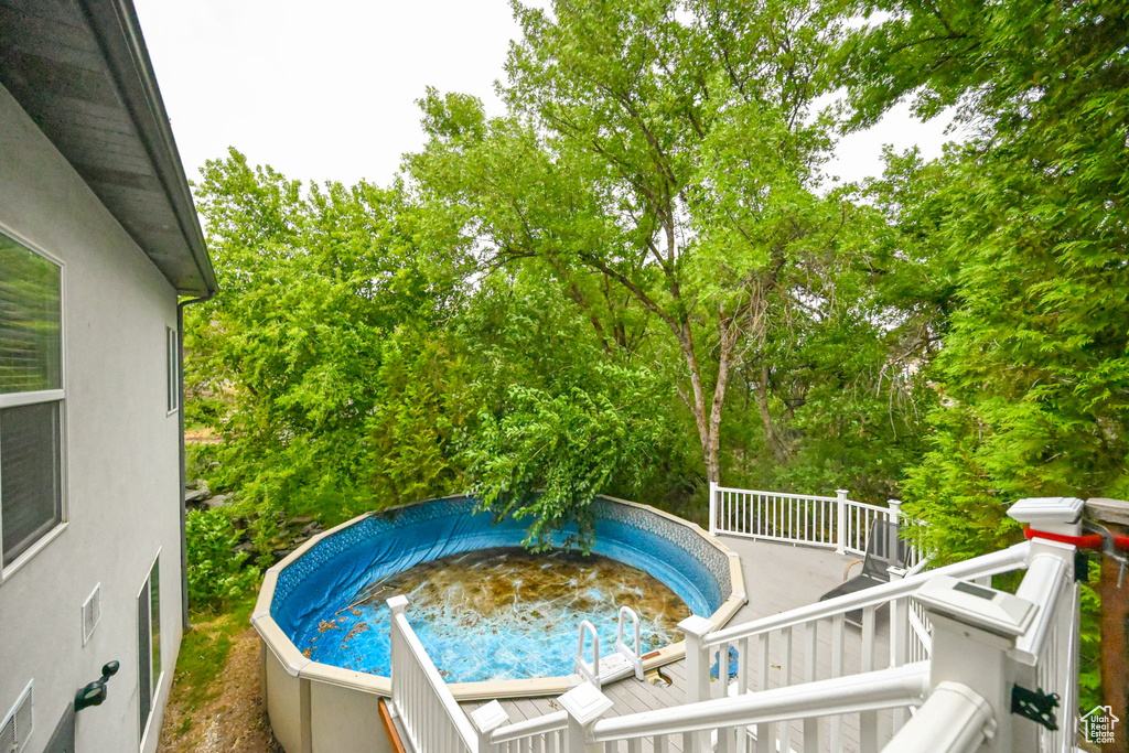 View of pool featuring a wooden deck and a jacuzzi