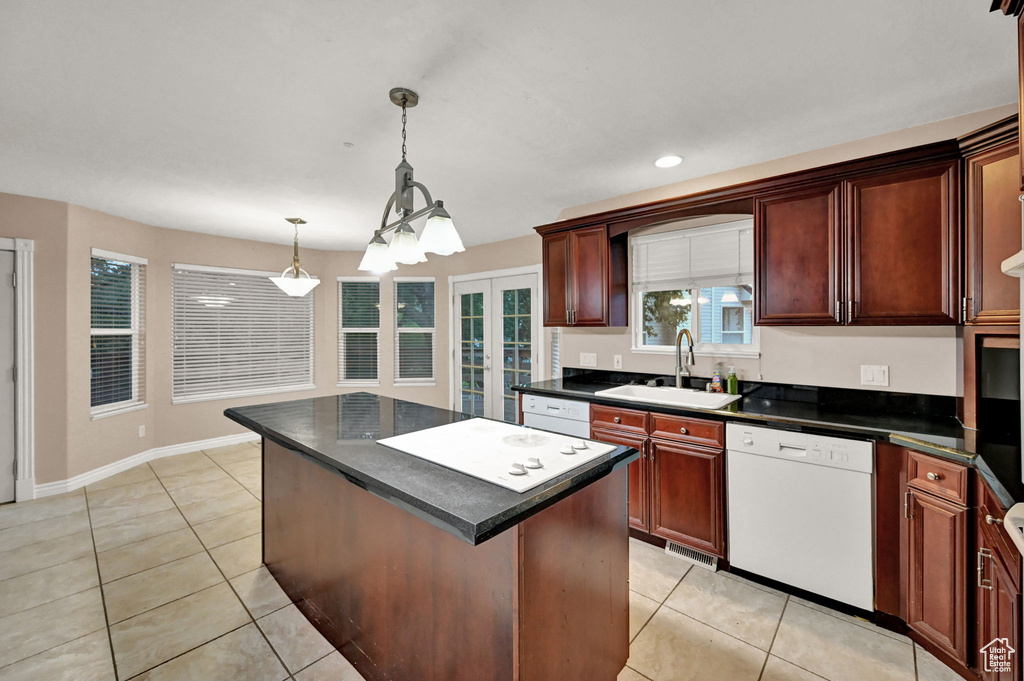 Kitchen with dishwasher, a sink, light tile patterned flooring, dark countertops, and recessed lighting