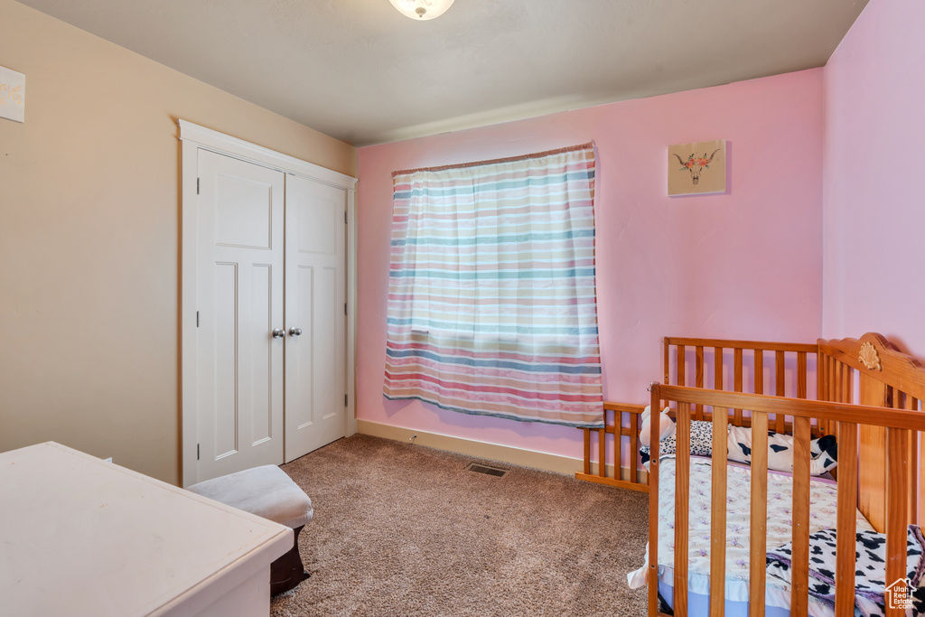 Carpeted bedroom with a closet