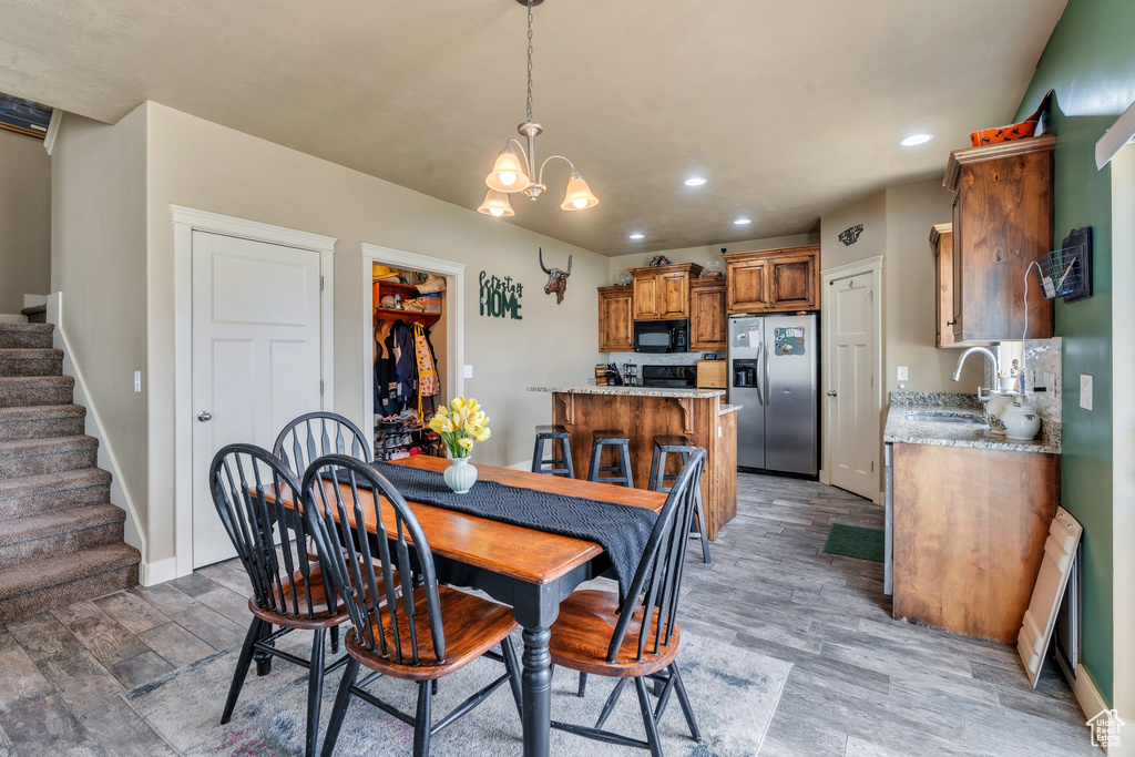 Dining room with stairs, recessed lighting, baseboards, a chandelier, and light wood-type flooring