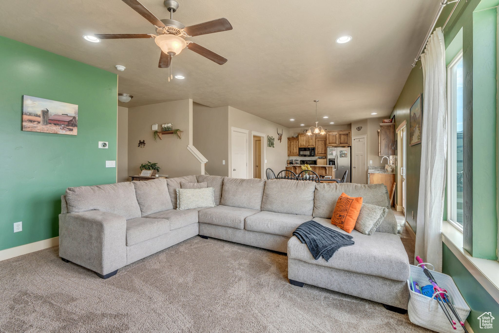 Living area with recessed lighting, a ceiling fan, a chandelier, healthy amount of natural light, and baseboards