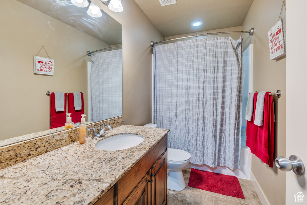 Full bath with toilet, vanity, shower / bath combo with shower curtain, and tile patterned floors
