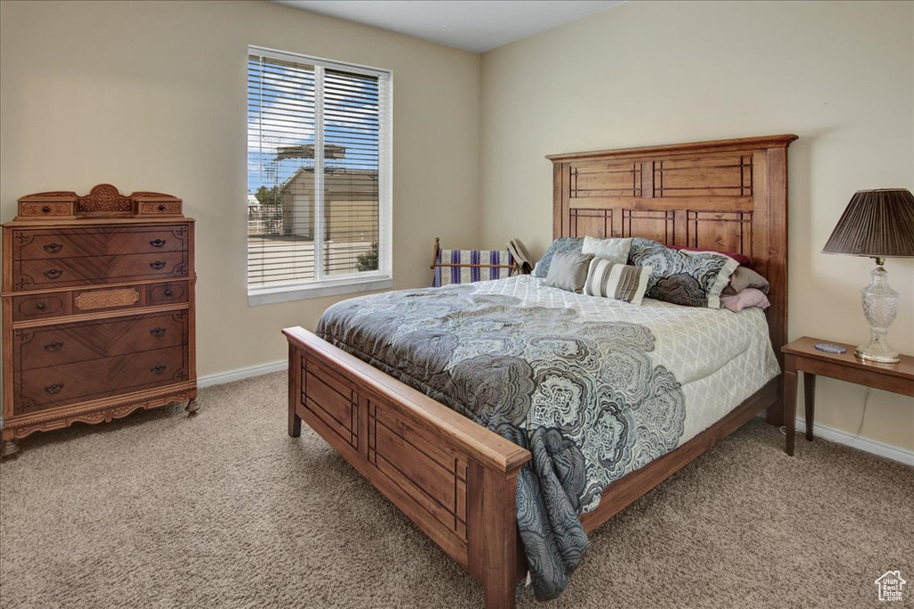 Bedroom featuring light carpet and baseboards