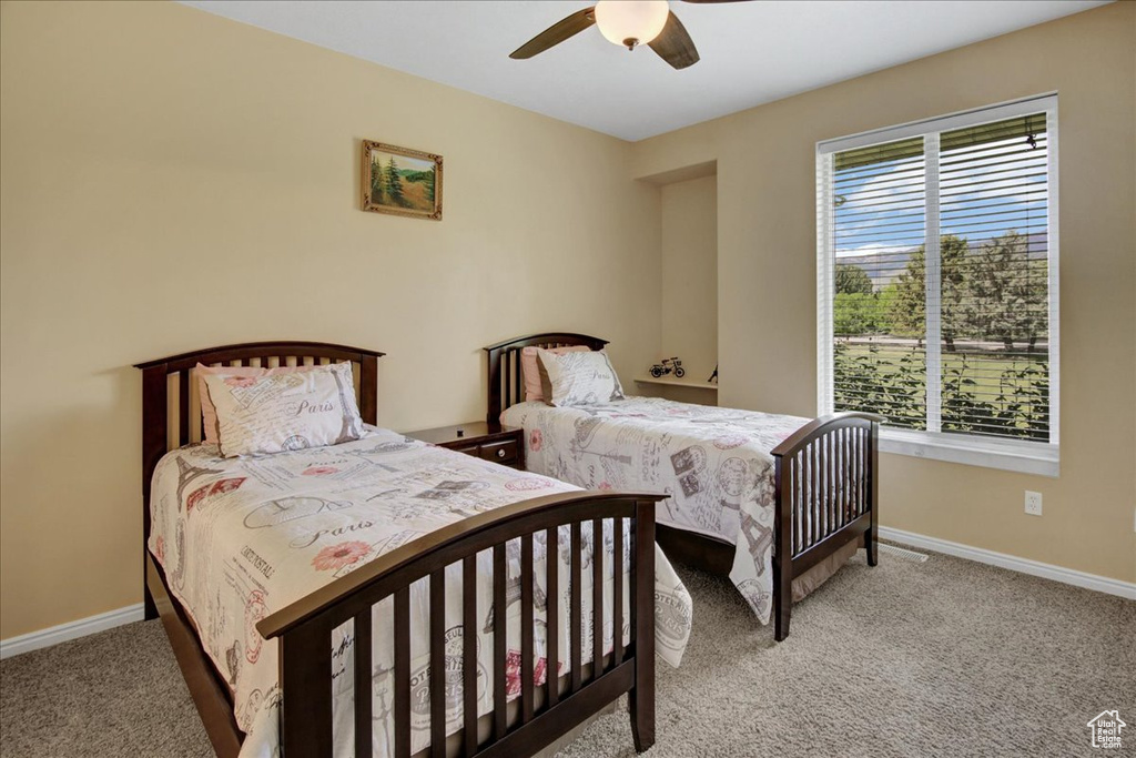 Bedroom with light carpet, baseboards, and ceiling fan