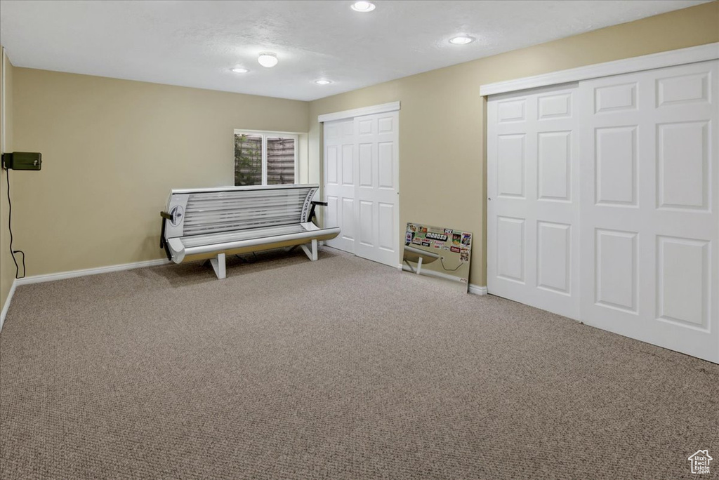 Living area with carpet flooring, baseboards, and recessed lighting