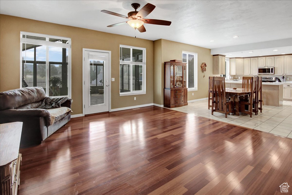 Living area with ceiling fan, light wood-style floors, baseboards, and recessed lighting