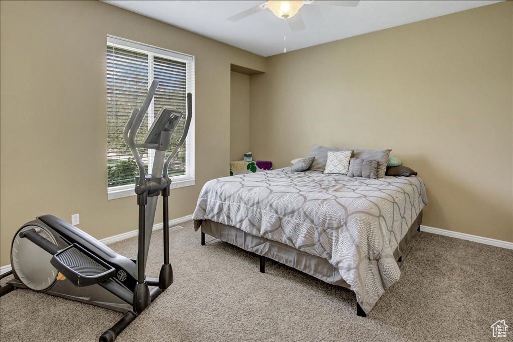 Carpeted bedroom featuring baseboards and ceiling fan