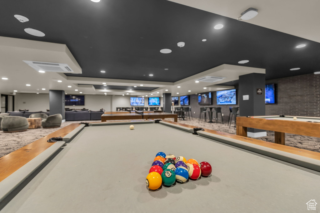 Rec room featuring billiards table, a raised ceiling, and a community bar