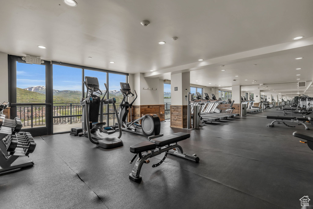 Gym featuring plenty of natural light, recessed lighting, a wall of windows, and a mountain view