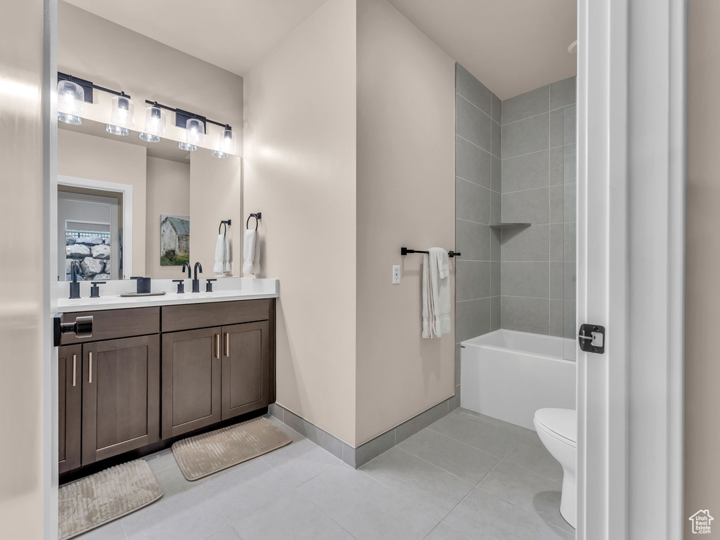 Bathroom with toilet, tile patterned flooring, vanity, and baseboards