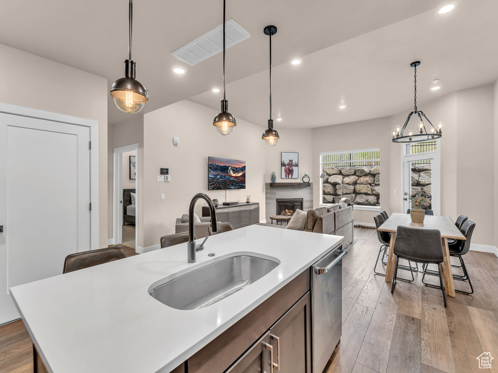 Kitchen featuring a sink, stainless steel dishwasher, light countertops, light wood finished floors, and recessed lighting