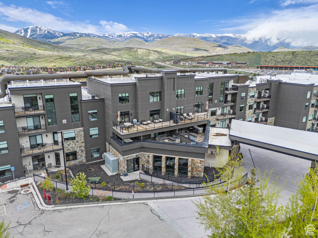 View of building exterior with fence and a mountain view