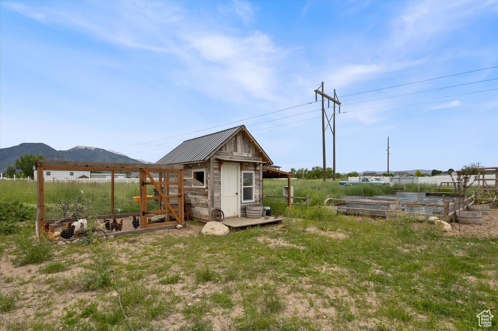 View of yard with exterior structure, an outdoor structure, a mountain view, and a vegetable garden