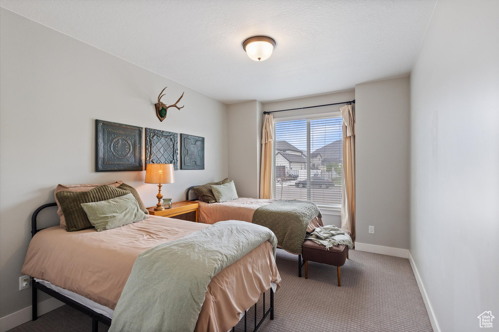 Bedroom featuring baseboards and carpet floors