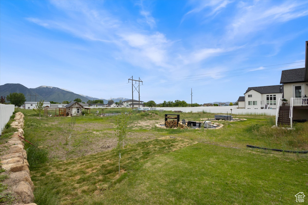 View of yard featuring fence, a mountain view, and stairs