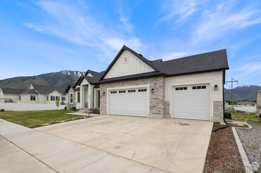 View of front facade with board and batten siding, a mountain view, concrete driveway, and a garage