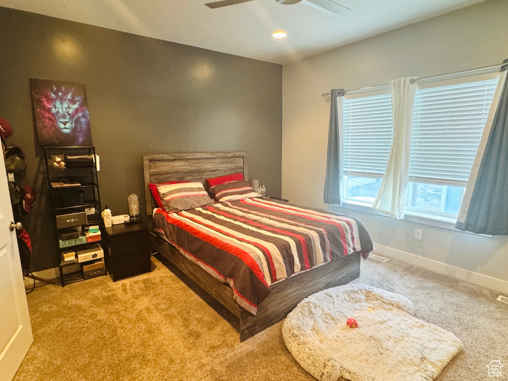 Carpeted bedroom featuring baseboards and a ceiling fan