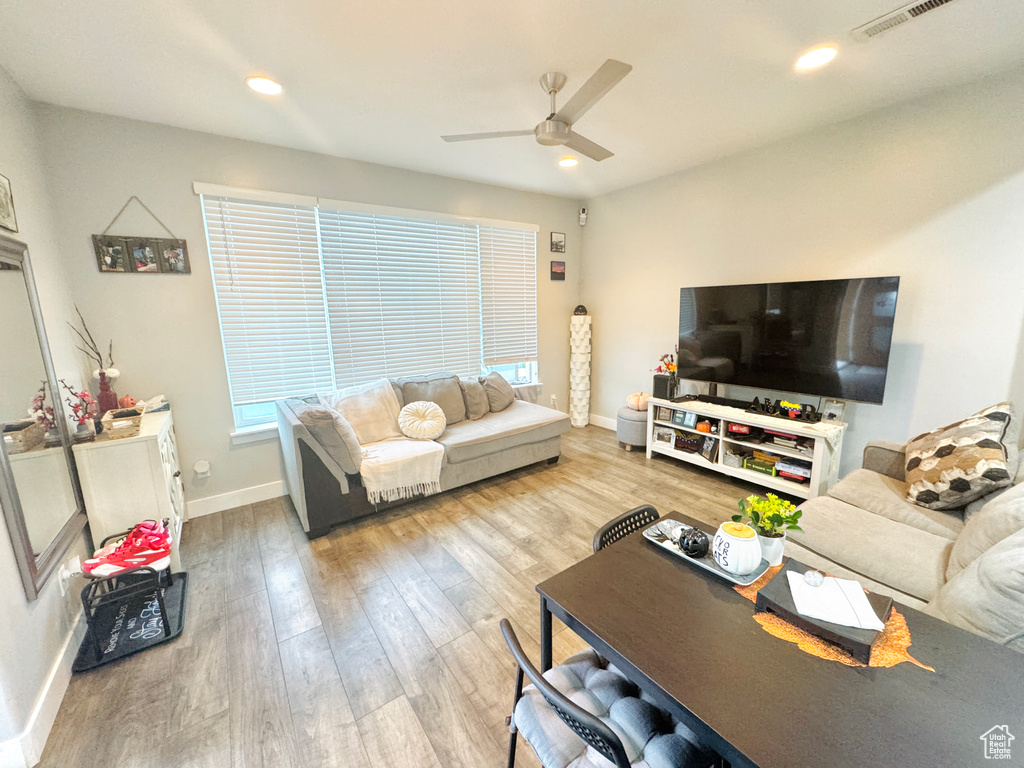 Living area featuring a ceiling fan, wood finished floors, baseboards, and recessed lighting