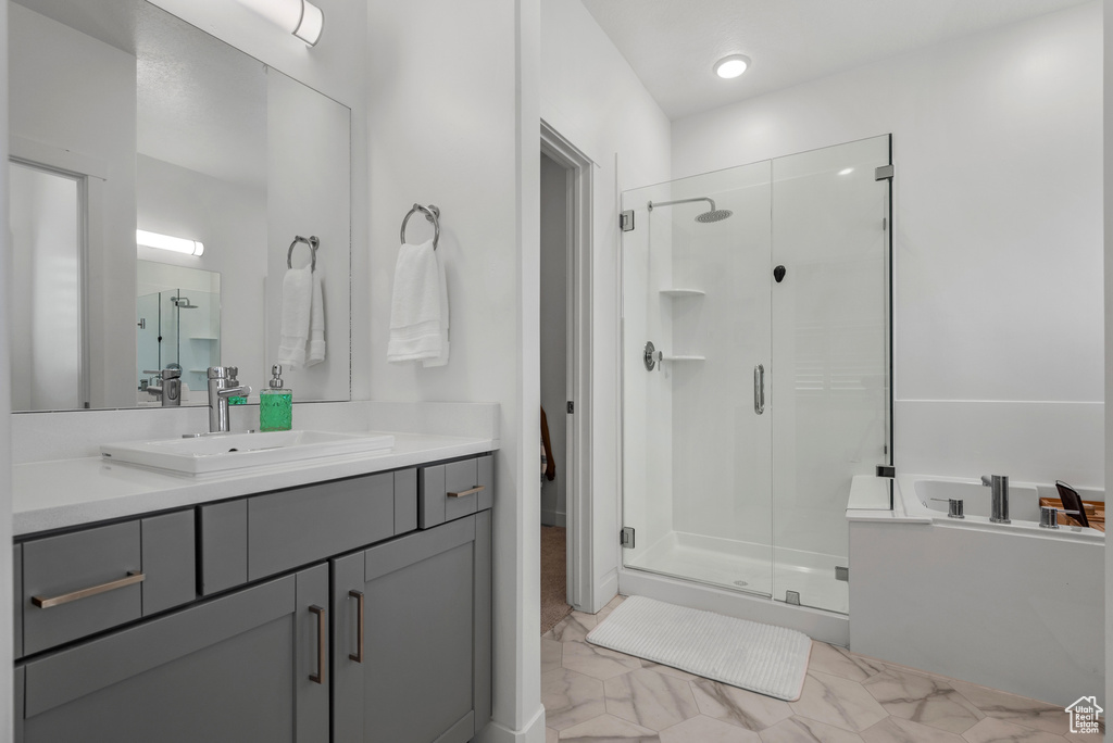 Full bathroom with a shower stall, vanity, and a garden tub