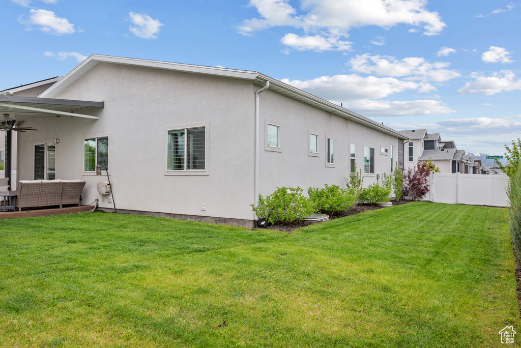 Rear view of property with an outdoor living space, ceiling fan, and stucco siding