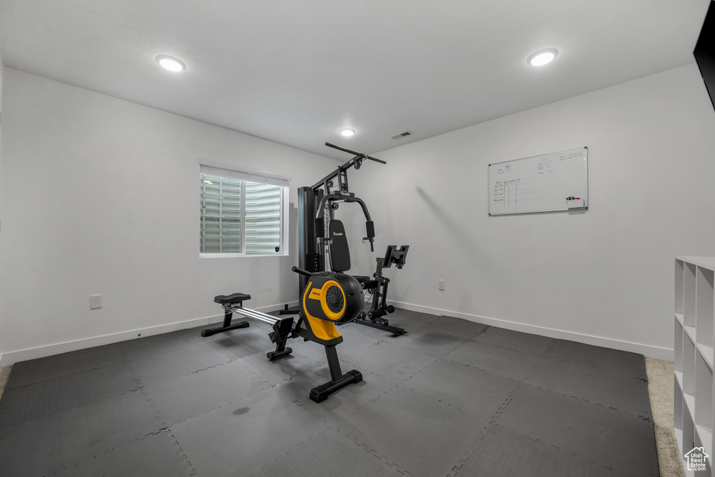 Exercise room with baseboards and recessed lighting